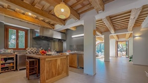 A spacious kitchen with wooden beams, a central island, and a view to the outside. - Villa in the Sibillini Mountains, Pool & Privacy (Sant'Angelo in Pontano)