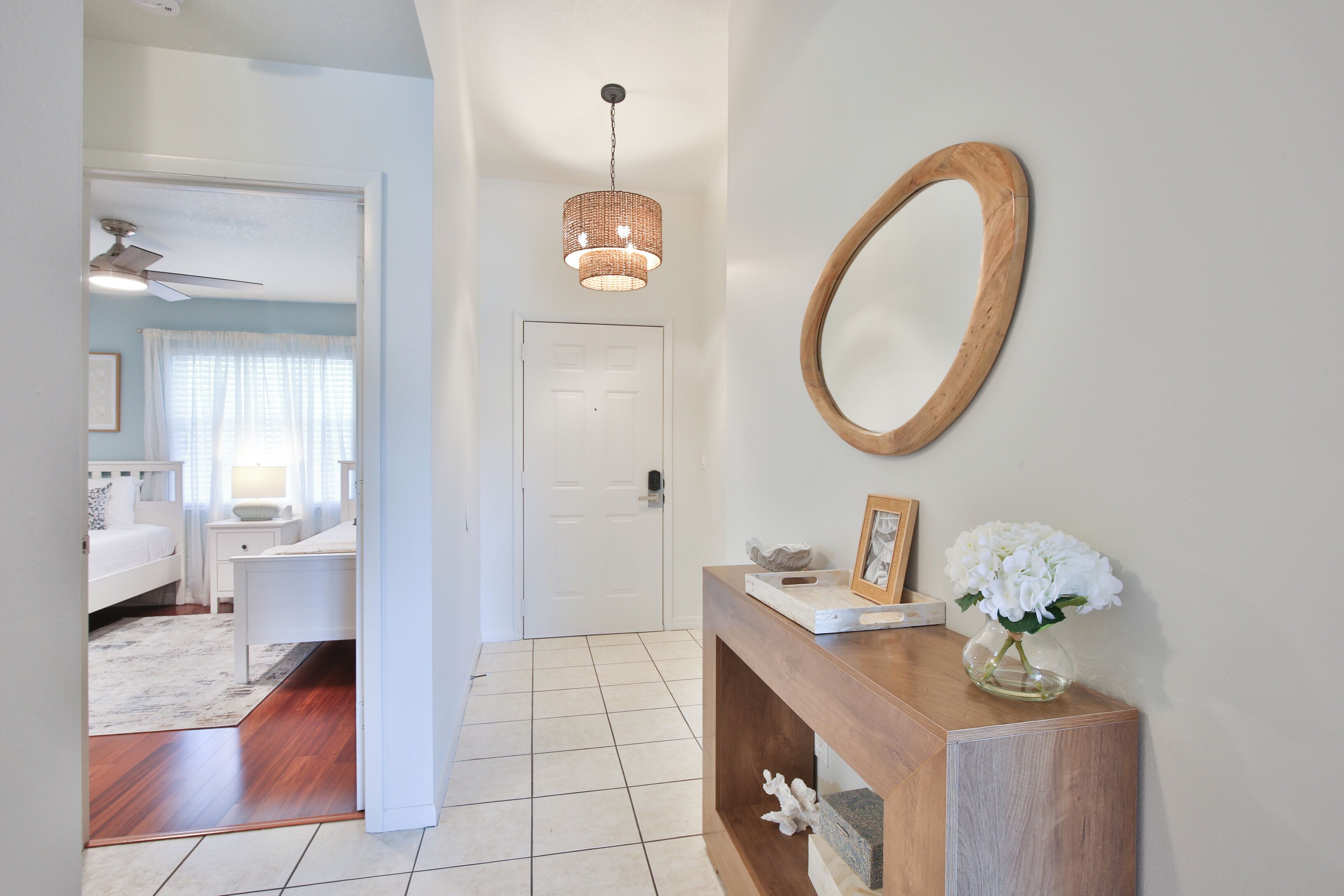 A hallway with a wooden console table, a mirror, and a ceiling fan.
