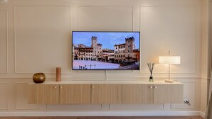 A television mounted on a wall with a view of a historic building. - The Golden Key
Your Charme Appartment in Tuscany (Arezzo)