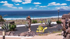 A rocky garden with cacti and a view of the ocean. - Casa Buenavista • Pool • Ocean views • Beach 2 min • LVH (Famara)