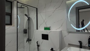 A modern bathroom with a glass-enclosed shower, a white toilet, a vanity with a mirror, and a sink. - 007s Tara-jre Jabal Al Lweibdeh With Stunning View (Amman)