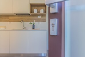 Eine moderne Küche mit weißen Schränken, einer Holzarbeitsplatte, einer eingebauten Ablage mit Behältern, einem Wasserhahn und einer Steckdose.