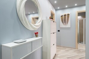 Un baño moderno con un espejo grande, un tocador blanco y una zona de ducha.