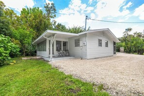 Une maison de plain-pied dotée d’un porche couvert, d’une allée en gravier et d’un petit jardin.