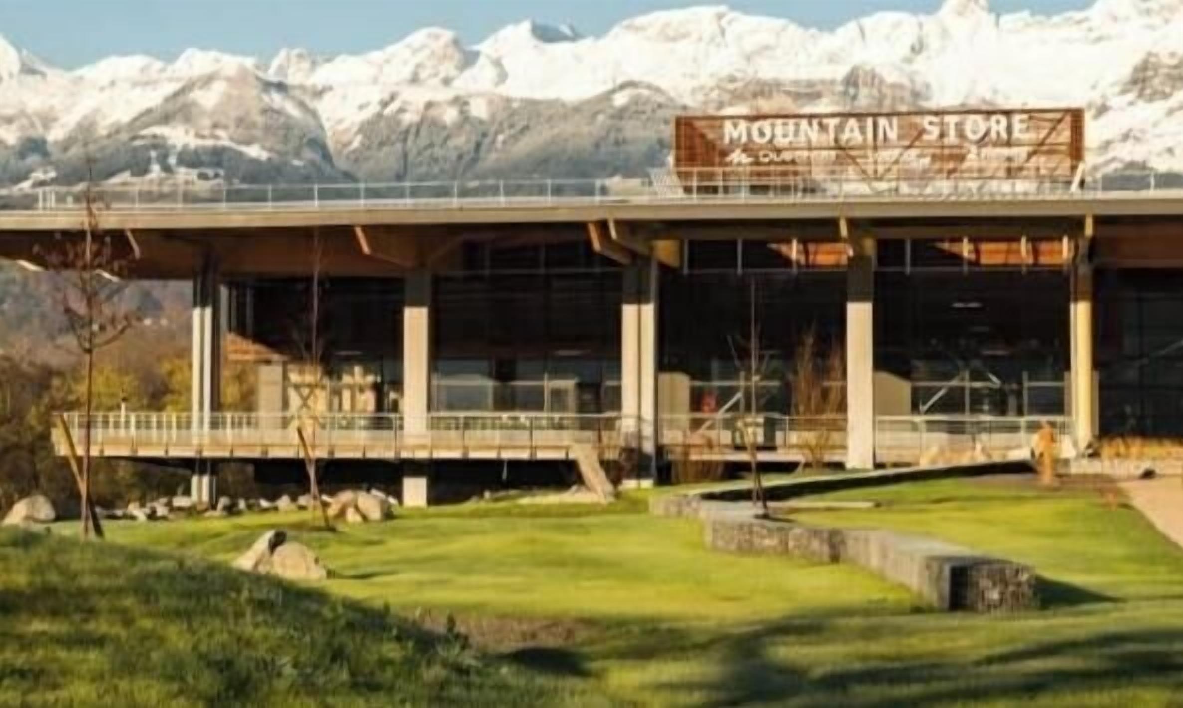 Un edificio con un cartello che riporta 'MOUNTAIN STORE' e una vista di montagne innevate sullo sfondo.