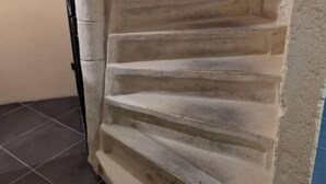 Eine Treppe aus Stein, die zu einer Zwischenebene führt.