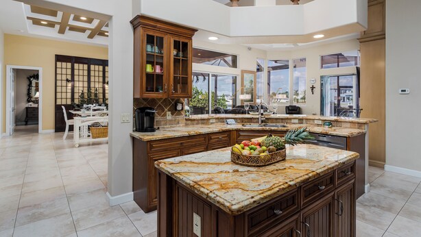 Una cocina amplia con una isla grande, armarios de madera y vistas al exterior.
