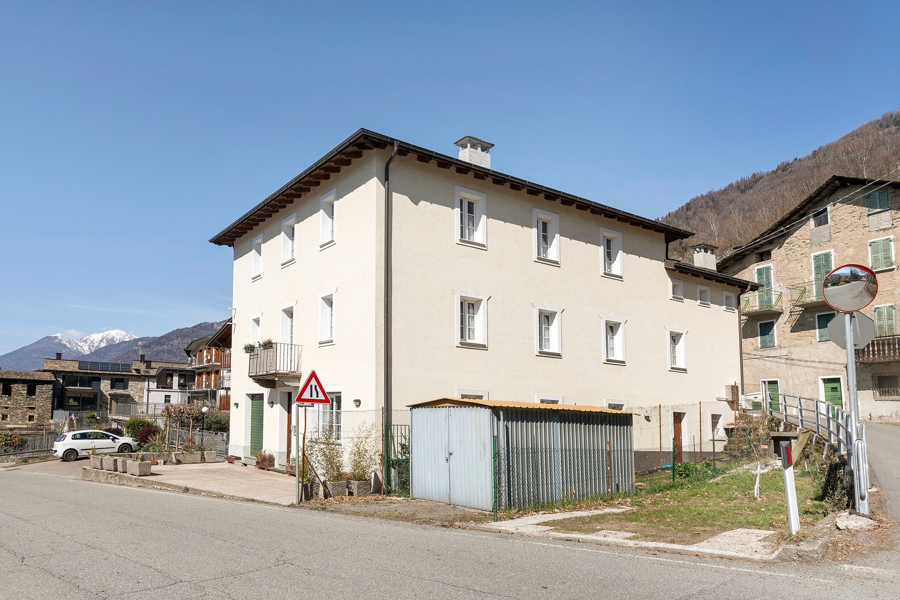 Ein mehrstöckiges Gebäude mit flachem Dach, mehreren Fenstern und einem sichtbaren Eingang.