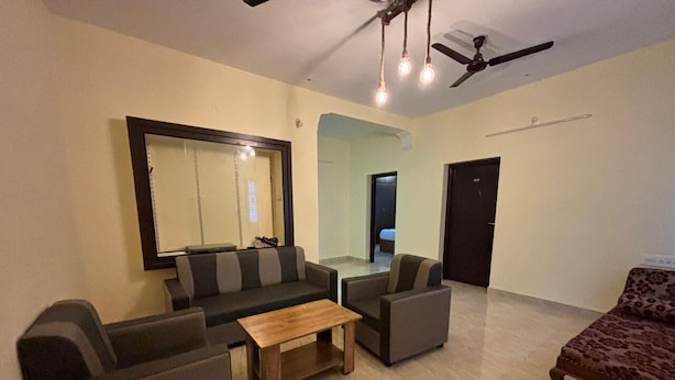 A living room with a sofa set, a coffee table, and a patterned armchair. - Thamira Residency (Palayankottai)