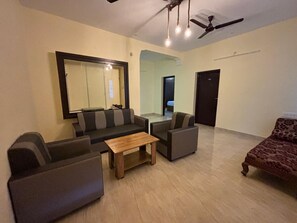 A living room with a sofa set, a coffee table, and a patterned armchair. - Thamira Residency (Palayankottai)