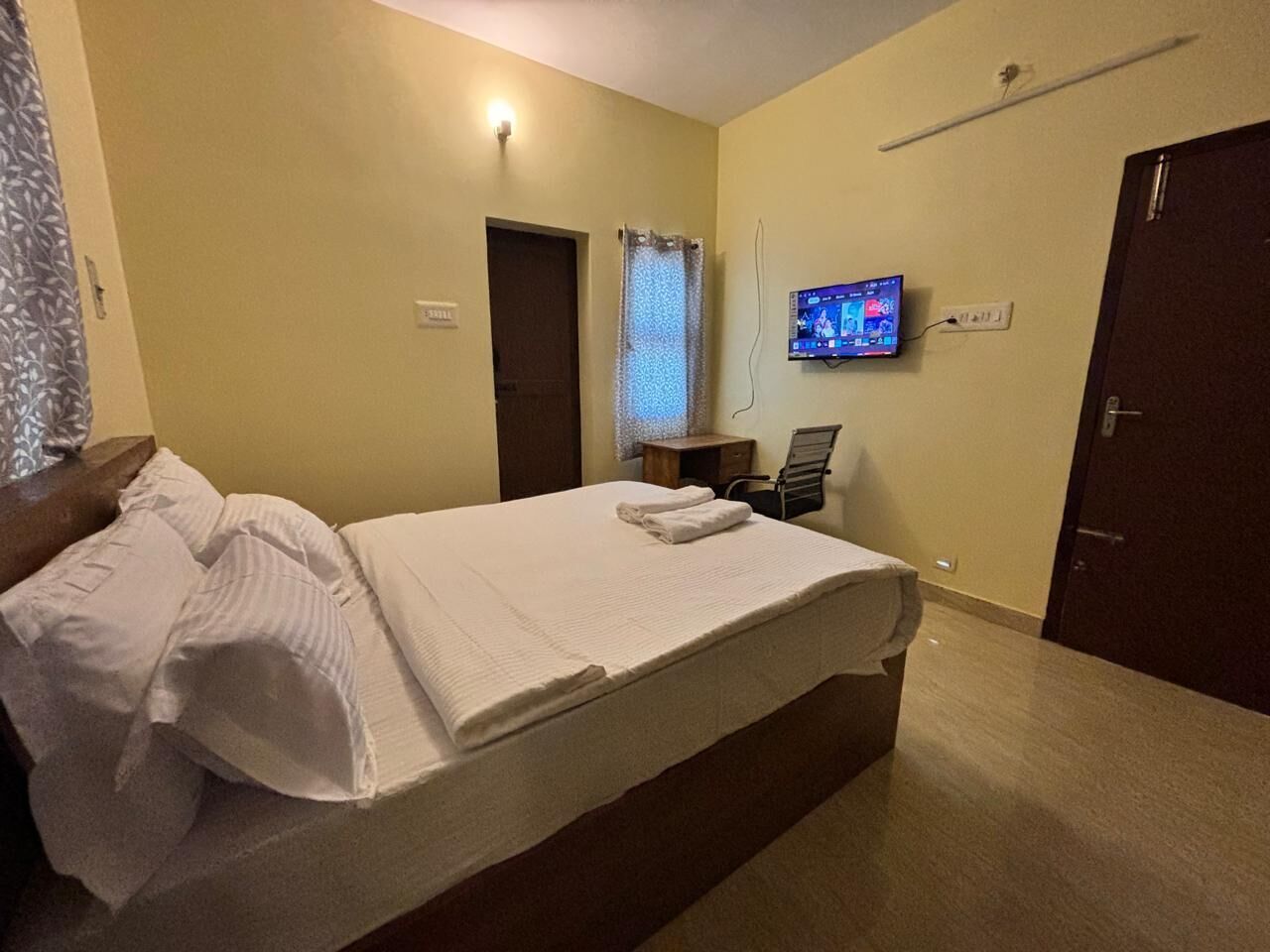 Ein Hotelzimmer mit einem Bett, einem Fernseher, einem Schreibtisch und einem Sessel.