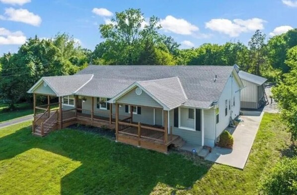 A single-story house with a porch, a covered front porch area, and a garage. - Spacious 5-bedroom house in beautiful Oak Grove with AC (Oak Grove)