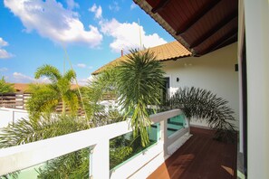 A balcony with a white railing, a tiled roof, and various green plants. - 3 BDR Private Pool Villa • 8 min to Ao Nang Beach (Ao Nang)