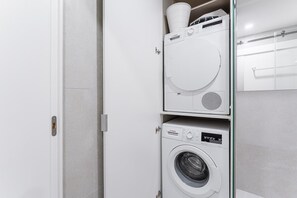 Et vaskerum med to Bosch vaskemaskiner stablet oven på hinanden og en tørretumbler.