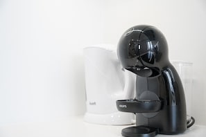 A black coffee machine with the brand 'KRUPS' on a white countertop. - GuestReady - Sleek mezzanine studio (Campanhã)