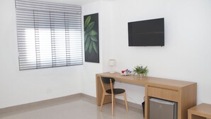 Een moderne kantoorruimte met een bureau, stoel en een kleine koelkast.