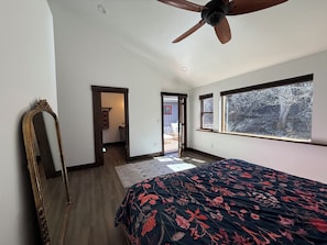 A bedroom with a bed, a ceiling fan, a mirror, and a window with a view of trees. - 3BR Farmhouse in Durango with Fitness Room, Sauna, Bidets, Theater Entertainment (Durango)