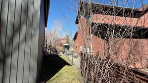 A building with a grey exterior, a fenced yard, and a clear blue sky. - 3BR Farmhouse in Durango with Fitness Room, Sauna, Bidets, Theater Entertainment (Durango)