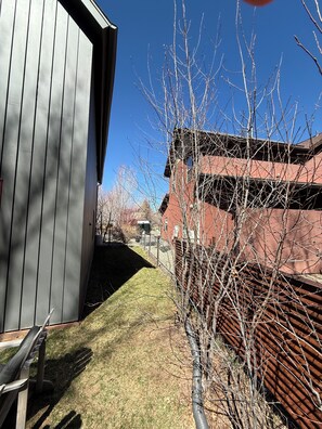 A building with a grey exterior, a fenced yard, and a clear blue sky. - 3BR Farmhouse in Durango with Fitness Room, Sauna, Bidets, Theater Entertainment (Durango)