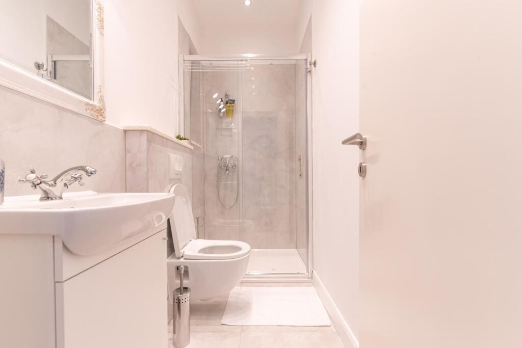Une salle de bain moderne équipée d’une douche, de toilettes et d’un lavabo.