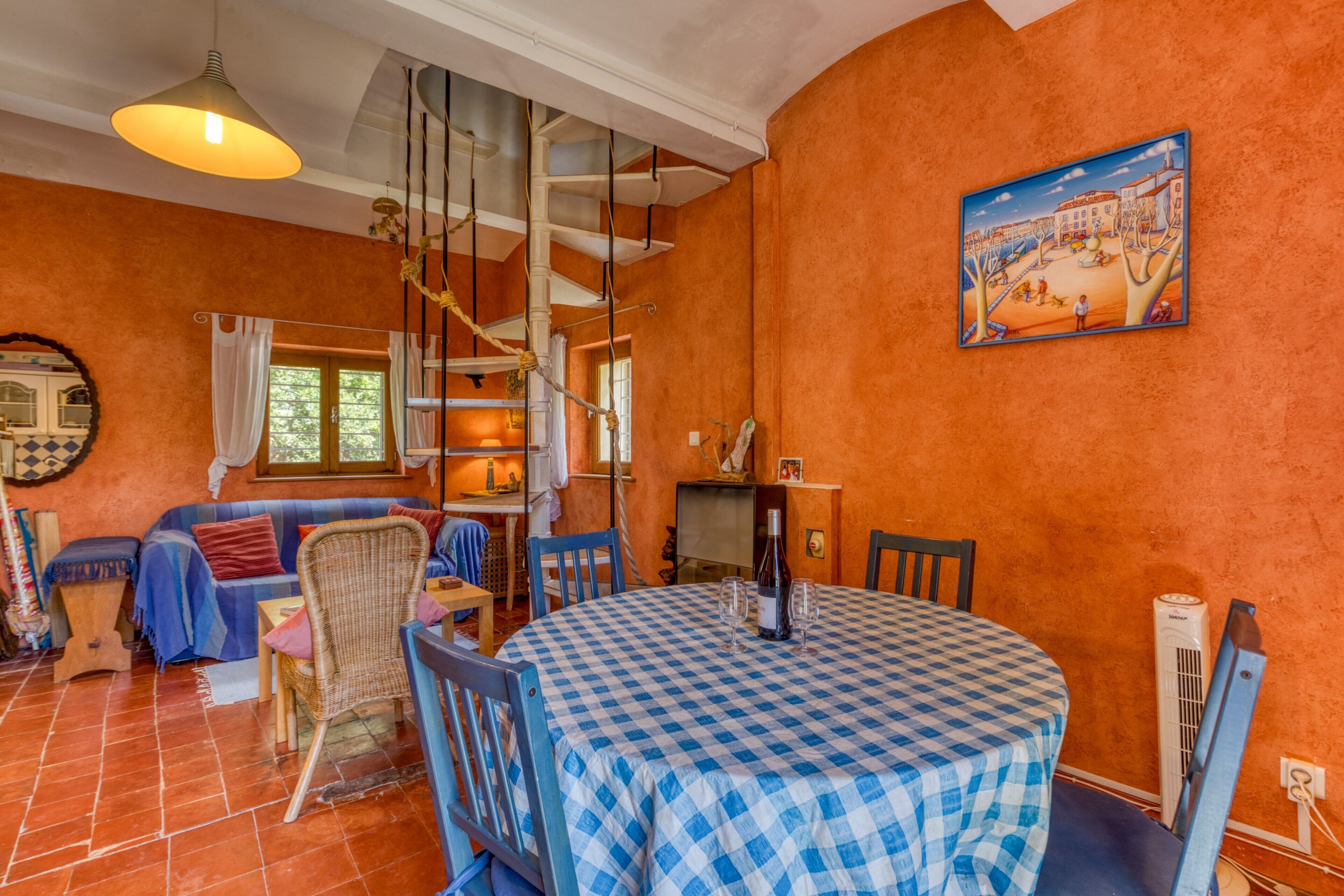 A cozy room with a checkered table, a sofa, and a painting on the wall.