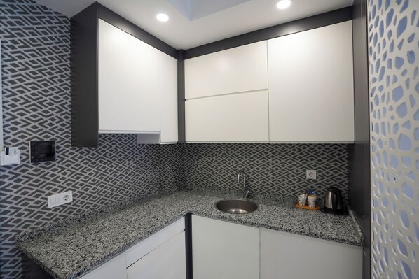 Eine moderne Küche mit einer Granitarbeitsplatte, einer Edelstahlspüle und einer gemusterten Spritzschutzwand.
