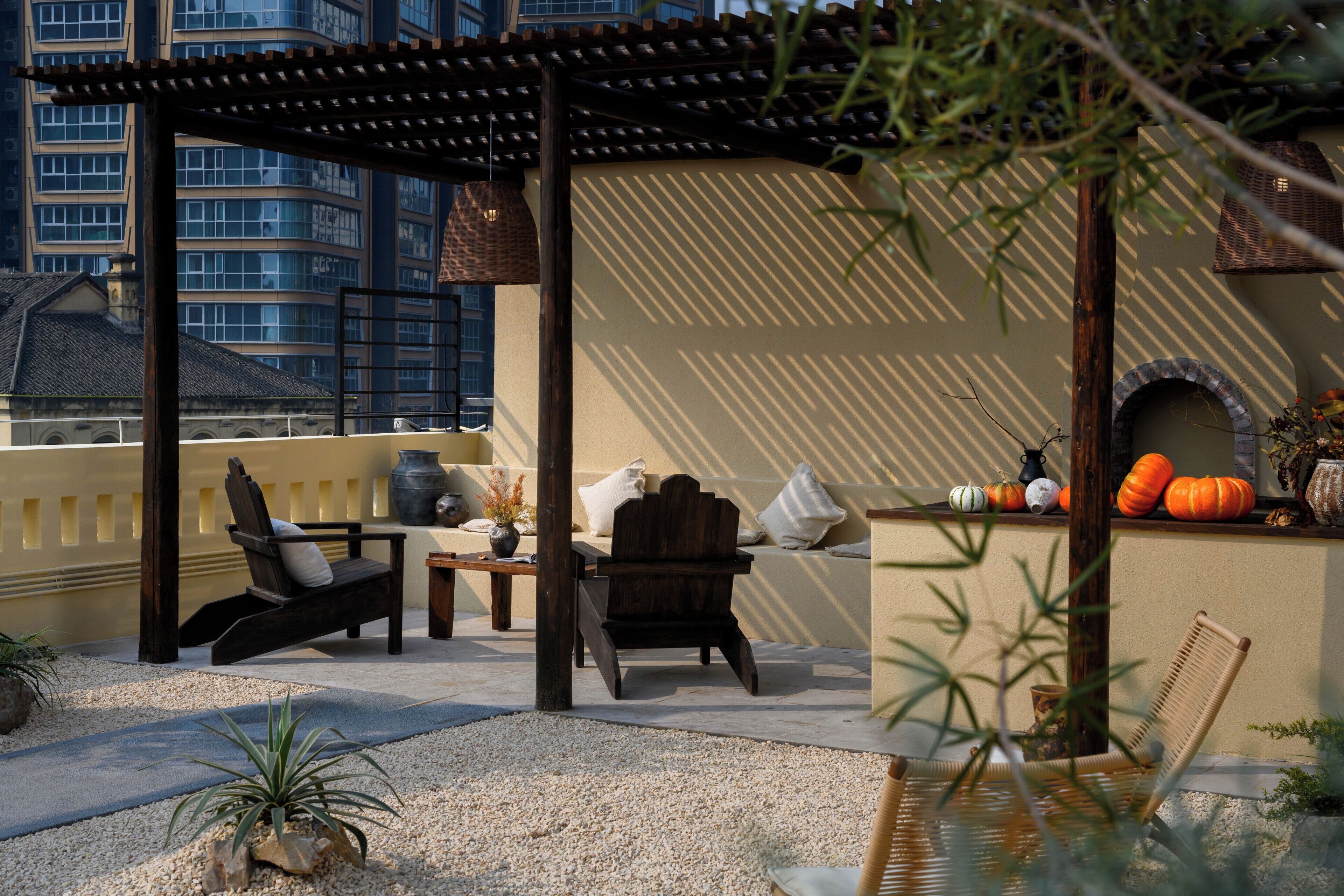 Une terrasse sur le toit avec des sièges extérieurs, une pergola, des citrouilles décoratives et une vue sur le paysage urbain.