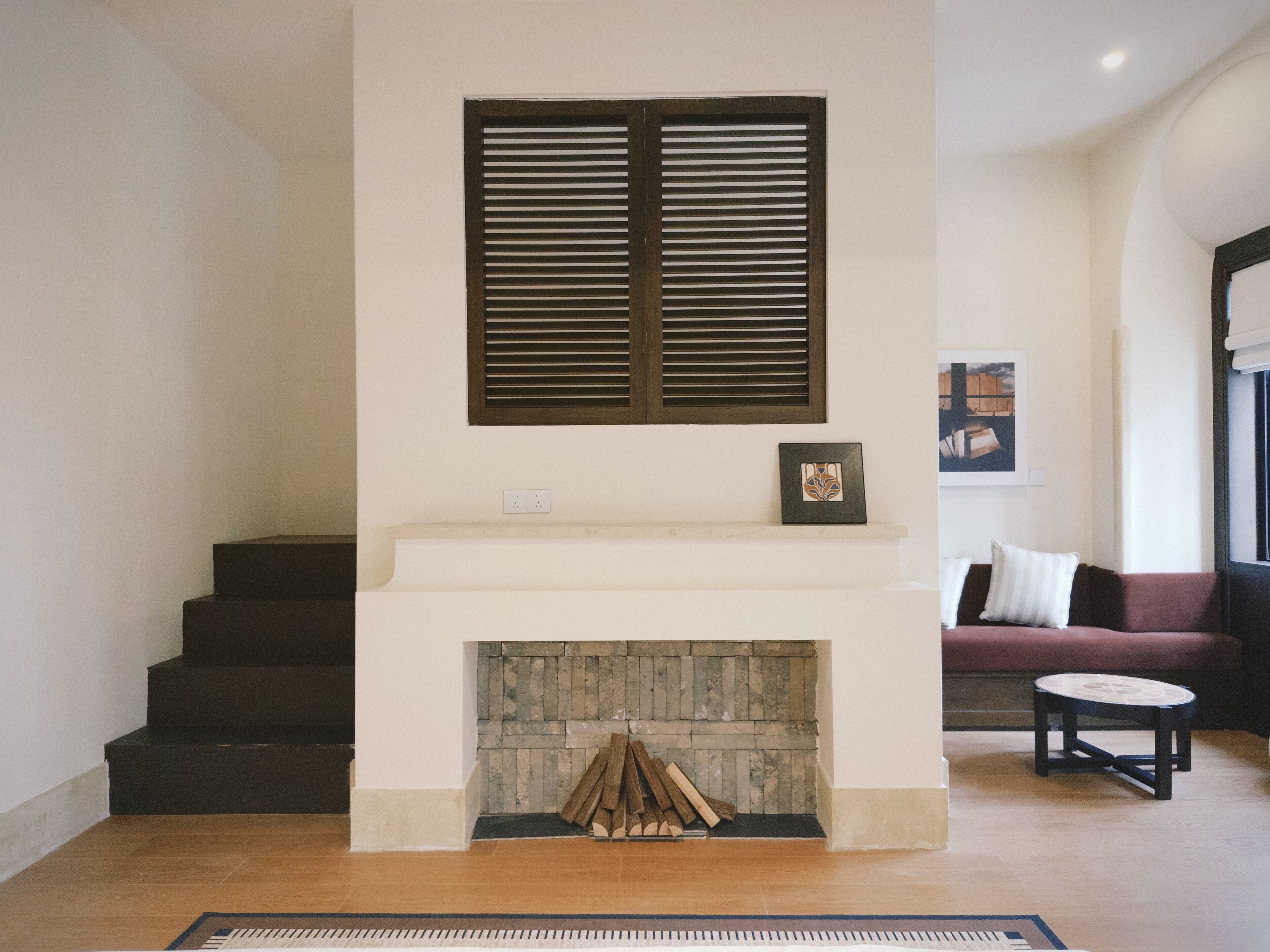 A living room with a fireplace, a staircase, and a sofa.