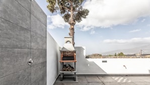 A rooftop patio with a brick oven, a tree, and a view of the landscape. - Apartment 'Cerca Nueva B1' with Sea View, Wi-Fi and Air Conditioning (El Paraíso)