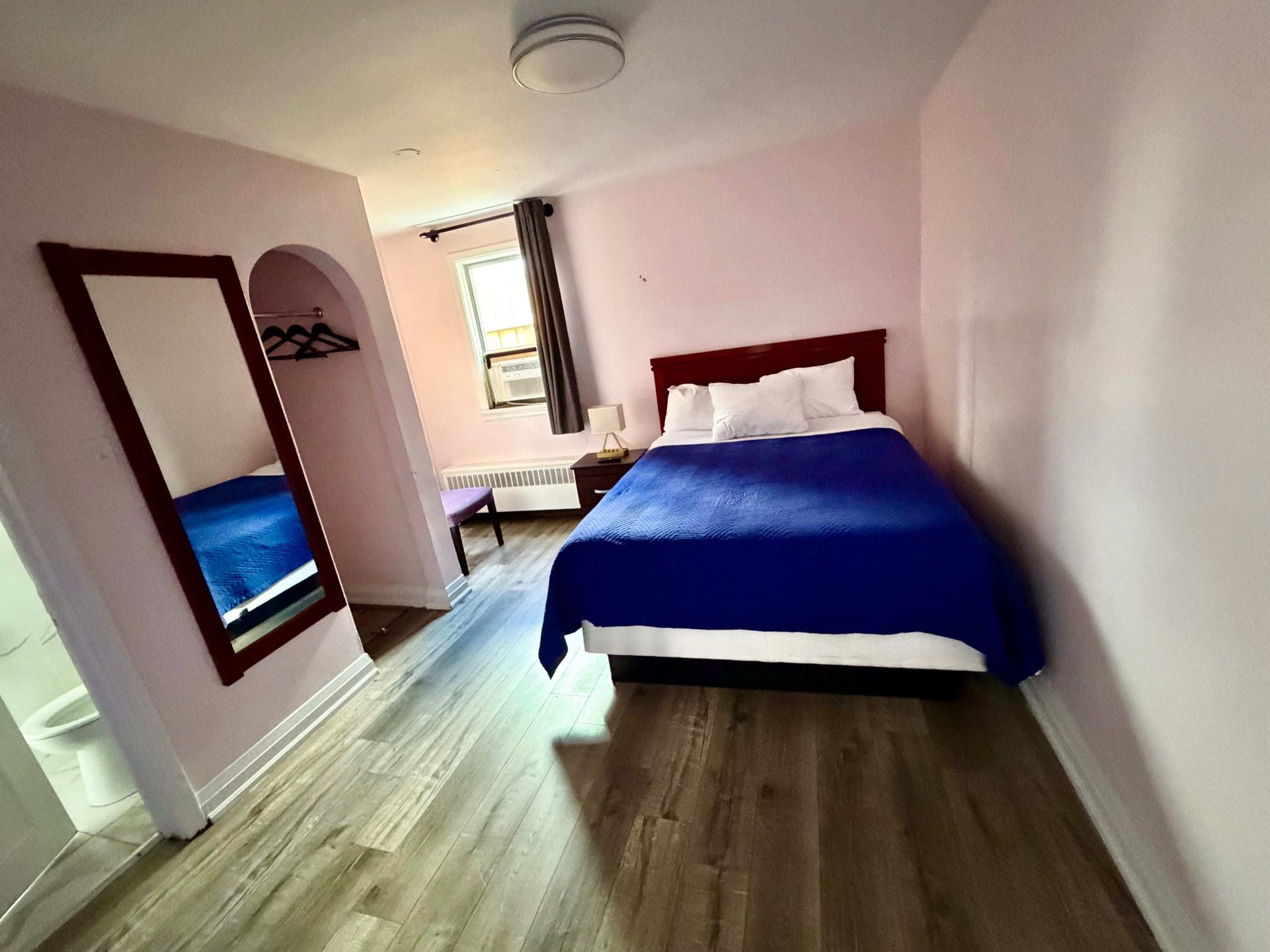 A bedroom with a bed, a desk, and a chair.