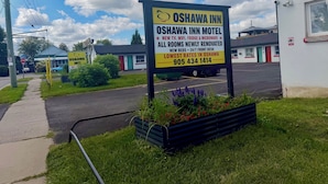 A sign for Oshawa Inn Motel advertising new amenities and contact information. - OSHAWA INN MOTEL (Oshawa)