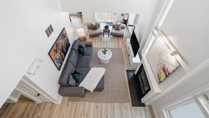 A modern living room with a sectional sofa, a coffee table, and a fireplace. - Modern Escape - Steps to Village + Summer Pool (The Blue Mountains)