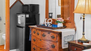 Eine Küche mit Kühlschrank, Mikrowelle und Holzkasten.