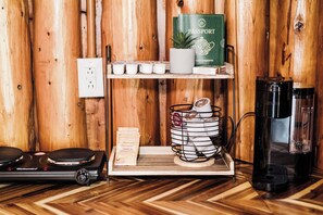 Un interior de madera con una cafetera, un pasaporte y una estantería con objetos pequeños.