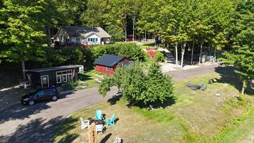 A residential area with a house, a red barn, and a driveway.