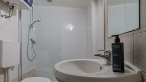 A bathroom with a white sink, toilet, and shower. - The Green Attic by Wonderful Italy (Torino)