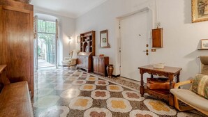 Un couloir doté d’un revêtement de sol à motifs, de meubles en bois et d’une porte donnant sur un espace extérieur.