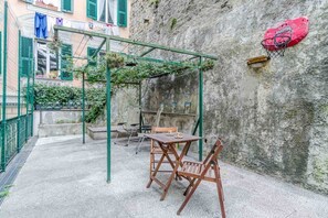 A patio with a table and chairs, a green pergola, and a basketball hoop. - GuestHost - Spacious and welcoming 120 square meters apartment, perfect for six people, located on the second floor of a historic building with an elevator (NOT accessible to disabled guests).The property is centrally located in Genoa, just a 5-minute wa (Genoa)