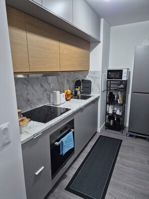 Une cuisine moderne équipée d’un four encastré, d’un four à micro-ondes et d’un évier.
