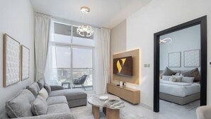 Ein modernes Wohnzimmer mit einer Couch, einem Couchtisch, einem Fernseher und einem Balkon.