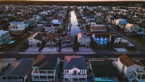 Una vista aerea di una zona residenziale con case, una strada centrale e una distesa d'acqua.
