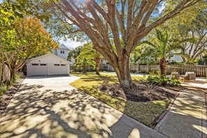 A residential driveway with a garage, a lawn, and a wooden fence. - Private Pool, 2 Min Walk to Beach, Perfect for Families and Couples (Isle of Palms)