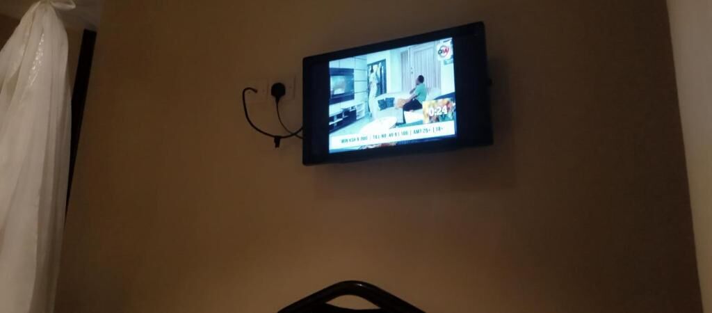 Ein an der Wand befestigter Fernseher mit sichtbarer Zeitanzeige.