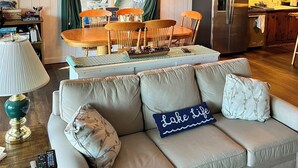 Un salon confortable avec un canapé, une table à manger et un coin cuisine équipé d’un réfrigérateur.