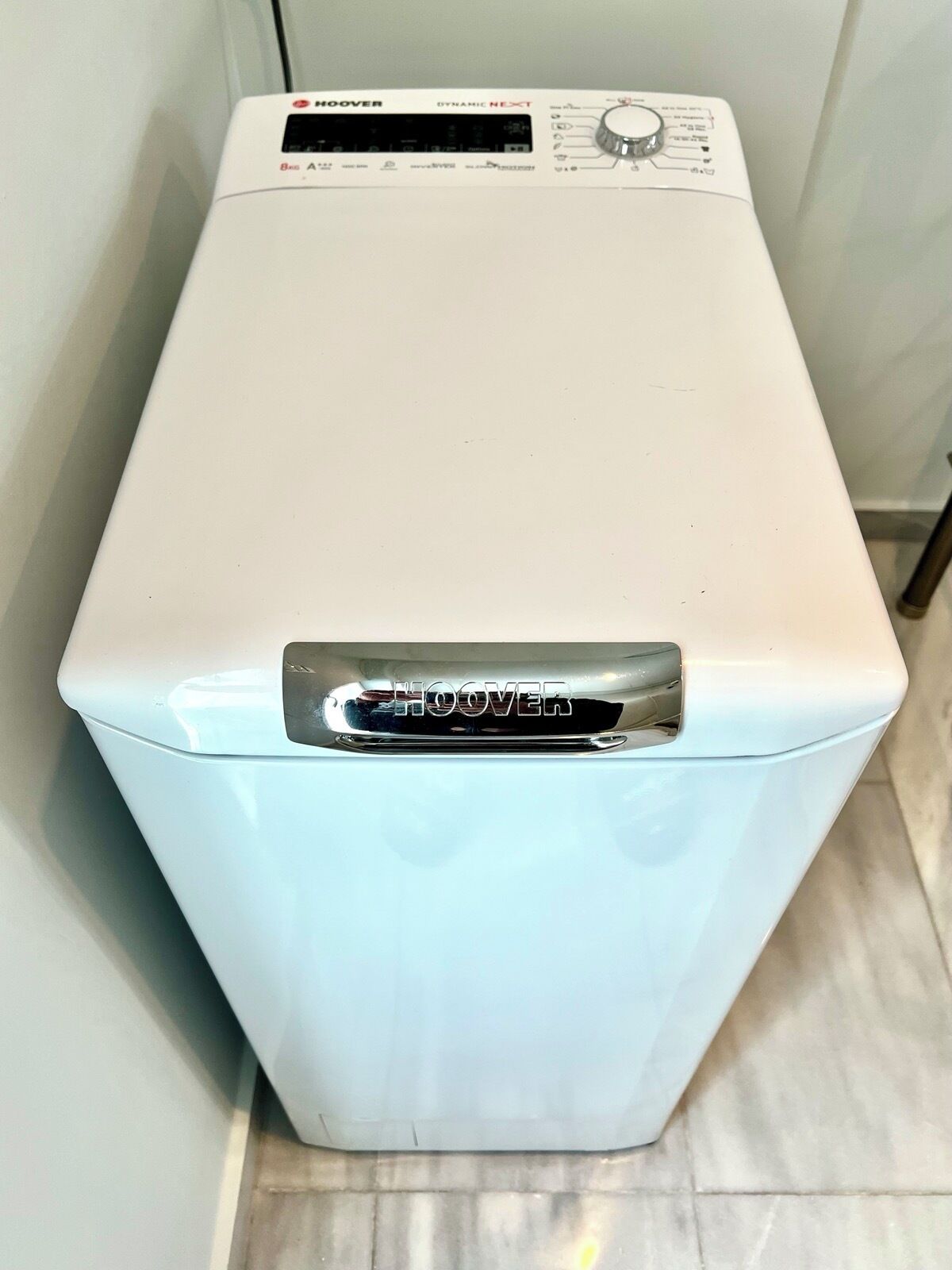 A white, rectangular, front-loading washing machine with a control panel and a brand name 'HOOVER' on the top.
