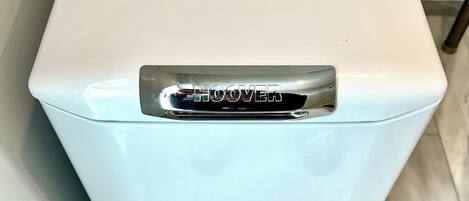 A white, rectangular, front-loading washing machine with a control panel and a brand name 'HOOVER' on the top.