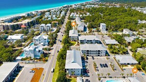 An aerial view of a coastal resort area with multiple buildings, a beach, and a swimming pool. - 30A - Hidden Lakes Condo Rentals (Santa Rosa Beach)