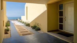 Ein Weg, der zu einem Gebäude mit einer Tür und Blick auf das Meer sowie einen klaren Himmel führt.