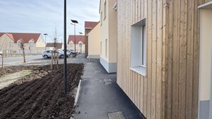 Un barrio residencial con casas, una acera pavimentada y una calle con coches estacionados.
