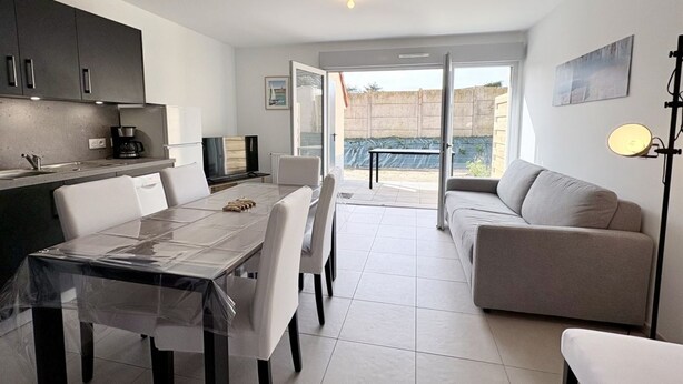 Una cocina moderna con comedor, un sofá y vistas al exterior.